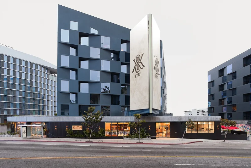 The KITH West Hollywood flagship, with the brand monogram carved into a pale stone tower above a full-height glass storefront