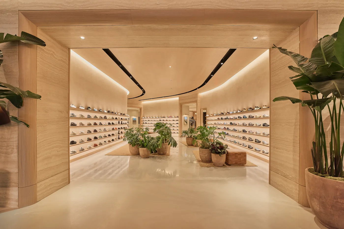 Curved pale-oak walls lined with footwear at KITH West Hollywood